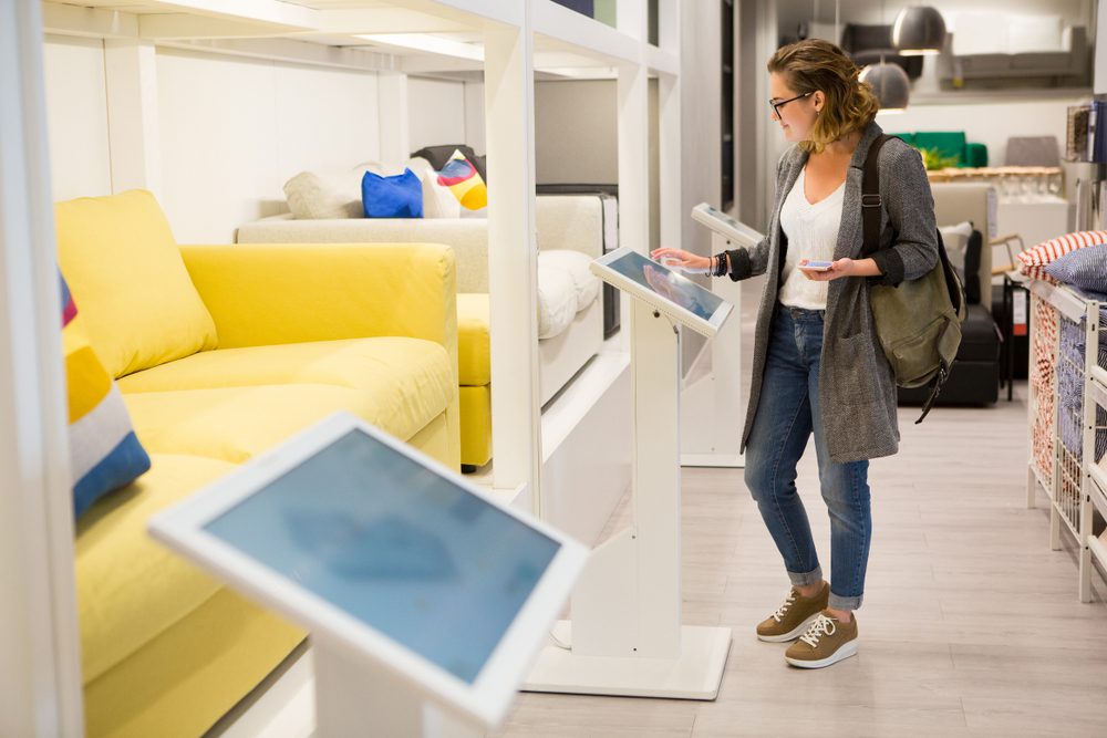 Woman,With,Phone,Configuring,Furniture,At,The,Self-service,Device,In